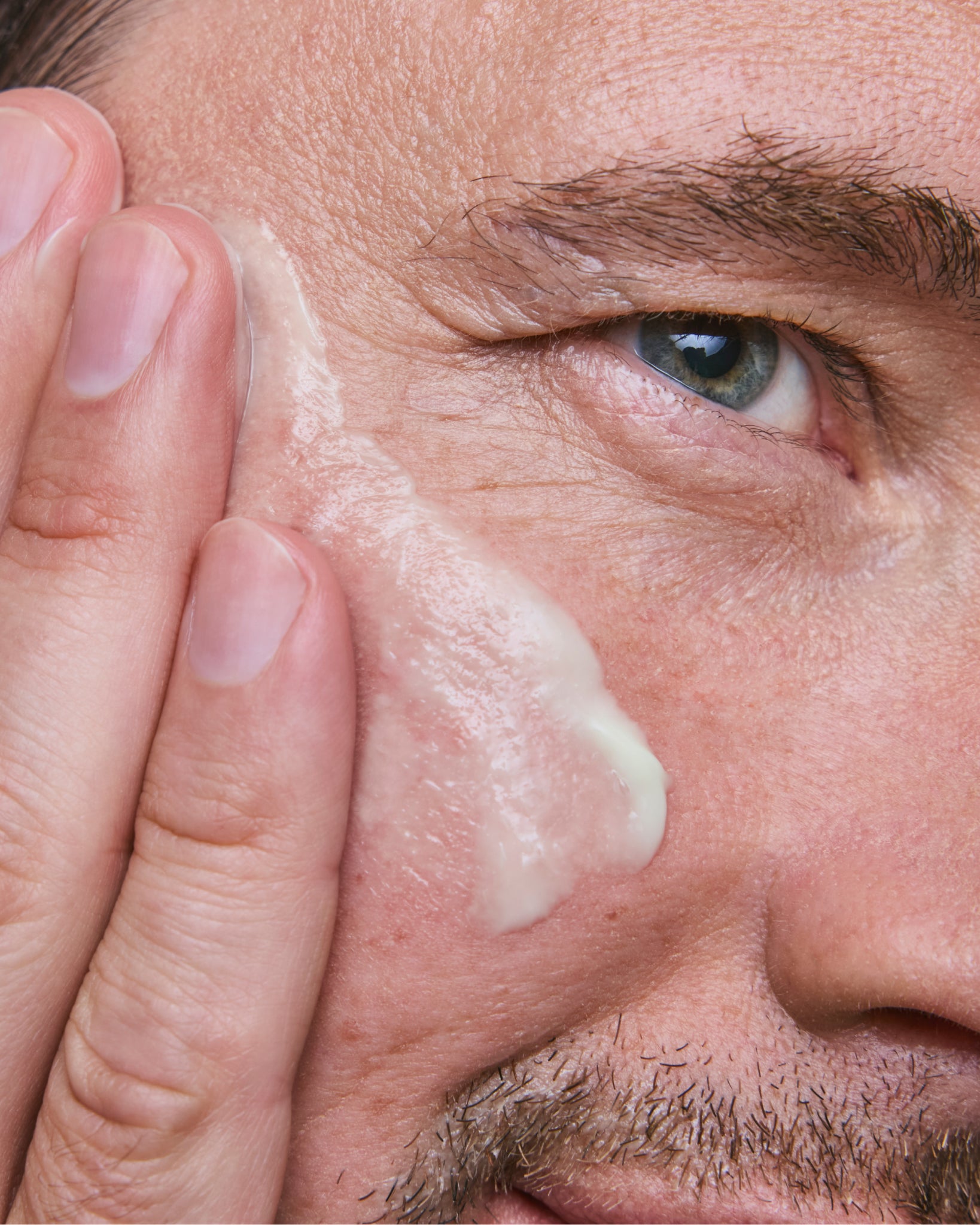 Model wearing MΓDARA Organic Skincare vitamin c face cream for men A5003 face cream on skin; close-up portrait shows natural application results.